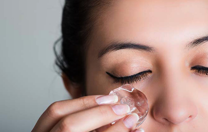 Девушка протирает лицо льдом