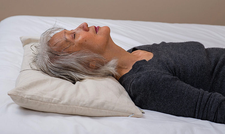 Женщина спит на гречневой подушке