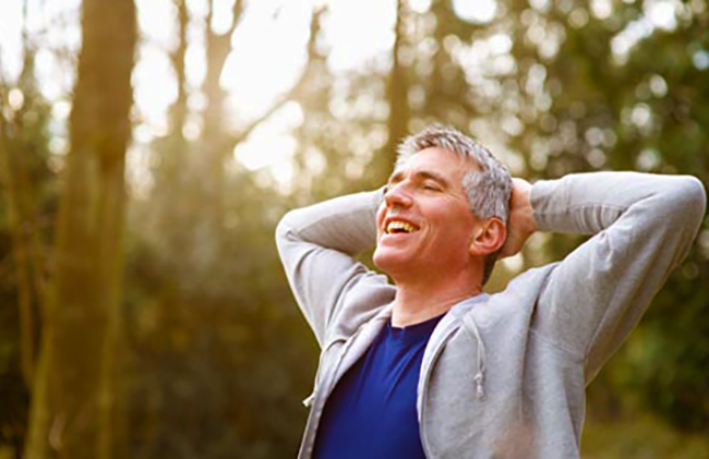 Мужчина дышит в сосновом лесу